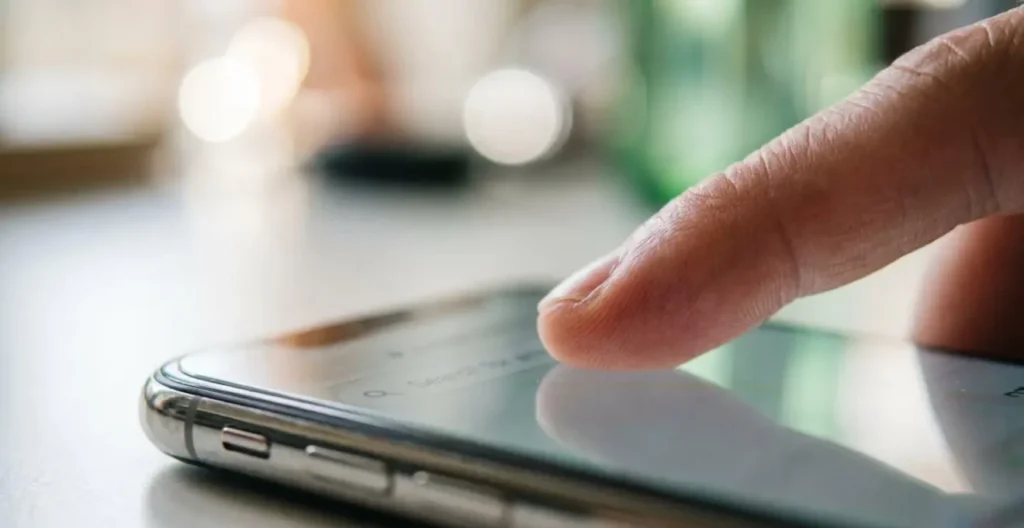 Macro extrême sur un doigt touchant l'écran d'un smartphone avec interface de recherche complètement floutée, faible profondeur de champ, arrière-plan bokeh Macro extrême sur un doigt touchant l'écran d'un smartphone avec interface de recherche complètement floutée, faible profondeur de champ, arrière-plan bokeh